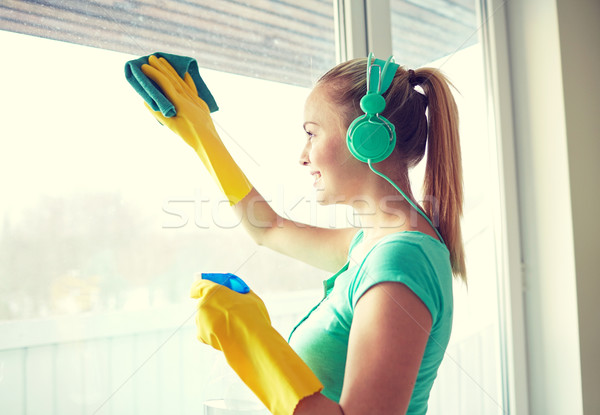 happy woman with headphones cleaning window Stock photo © dolgachov