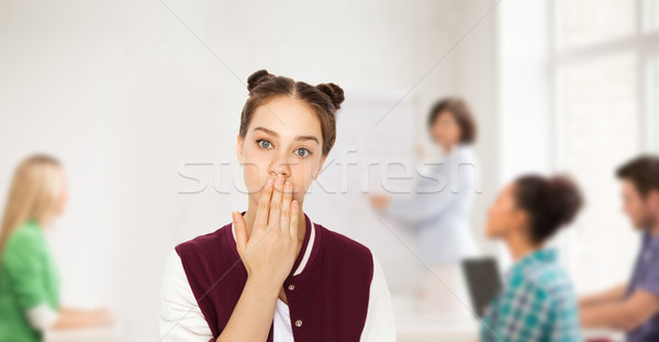 confused student girl covering her mouth by hand Stock photo © dolgachov