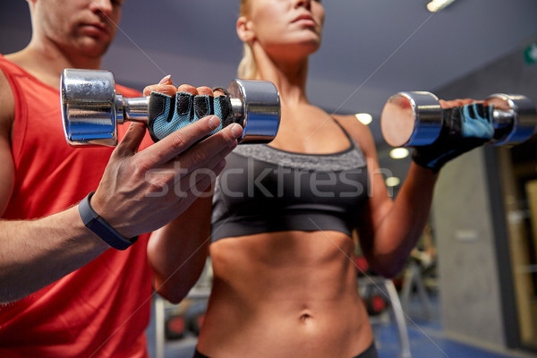 young couple with dumbbell flexing muscles in gym Stock photo © dolgachov