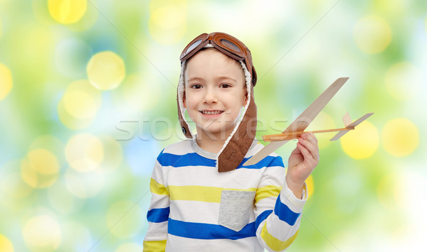 happy little boy in aviator hat with airplane Stock photo © dolgachov