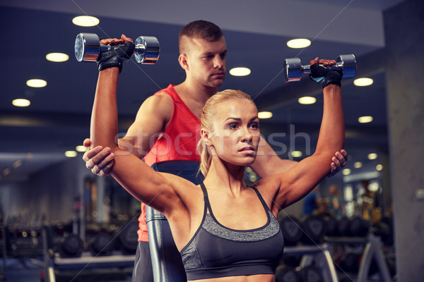 man and woman with dumbbells in gym Stock photo © dolgachov