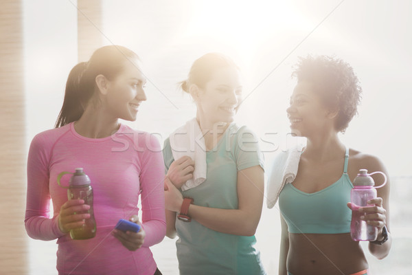 happy women with bottles of water in gym Stock photo © dolgachov