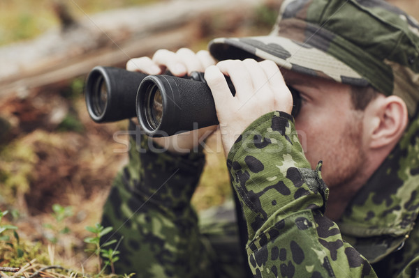 young soldier or hunter with binocular in forest Stock photo © dolgachov