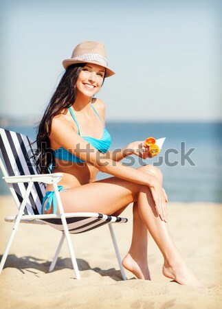 woman sunbathing and spraying sunscreen on beach Stock photo © dolgachov