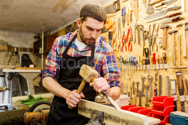 carpenter with wood, hammer and chisel at workshop Stock photo © dolgachov