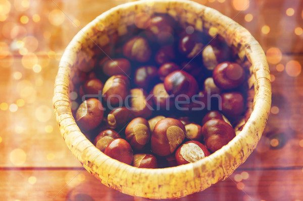 close up of chestnuts in basket on wooden table Stock photo © dolgachov