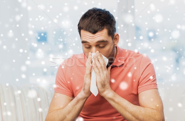 sick man blowing nose to paper napkin at home Stock photo © dolgachov