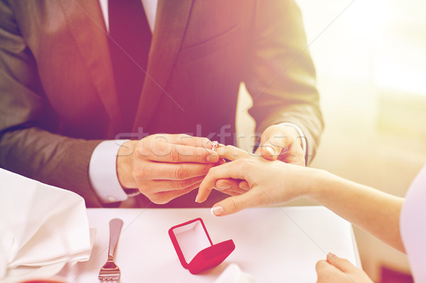 close up of man putting ring to his fiance finger Stock photo © dolgachov