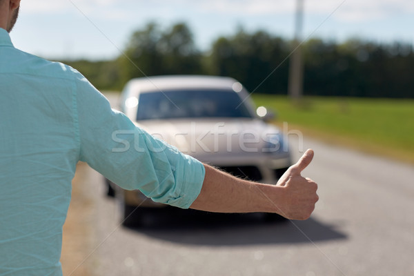 man hitchhiking and stopping car with thumbs up Stock photo © dolgachov