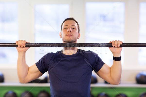man exercising on bar and doing pull-ups in gym Stock photo © dolgachov