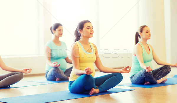 happy pregnant women exercising yoga in gym Stock photo © dolgachov