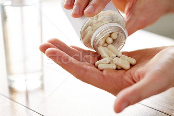 Közelkép férfi áramló tabletták bögre kéz Stock fotó © dolgachov