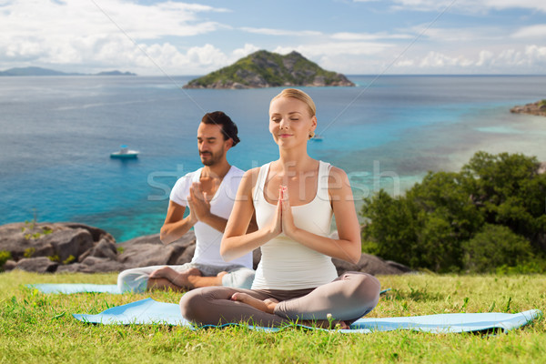 happy couple doing yoga and meditating outdoors Stock photo © dolgachov