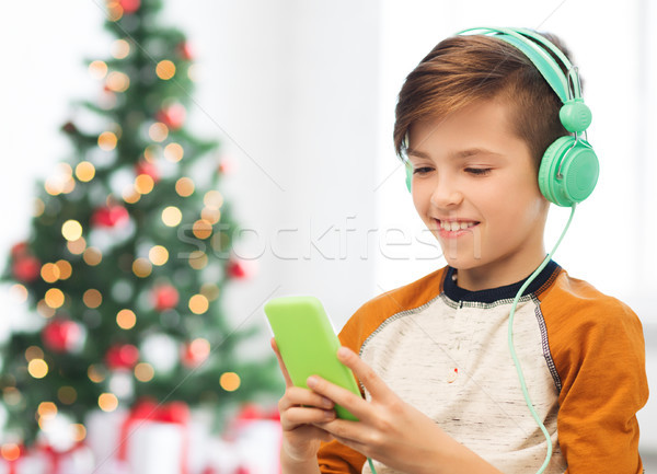 Stock photo: boy with smartphone and headphones at christmas