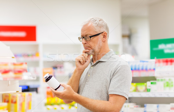 senior male customer with drug at pharmacy Stock photo © dolgachov
