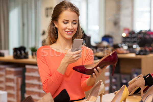 woman taking photo by smartphone at shoe store Stock photo © dolgachov
