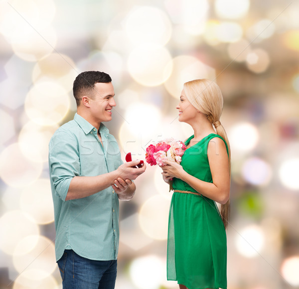 smiling couple with flower bouquet and ring Stock photo © dolgachov