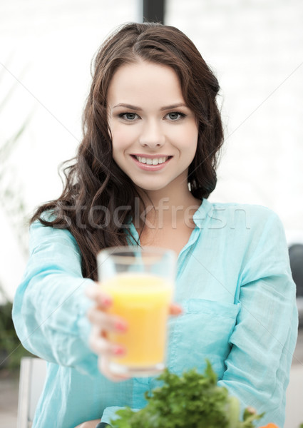 young woman holding glass of orange juice Stock photo © dolgachov