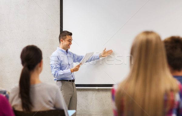 group of students and smiling teacher with notepad Stock photo © dolgachov