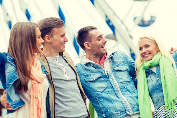 group of smiling friends in amusement park Stock photo © dolgachov