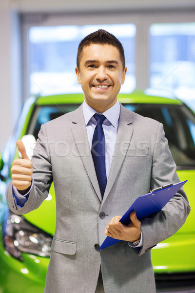 man showing thumbs up at auto show or car salon Stock photo © dolgachov