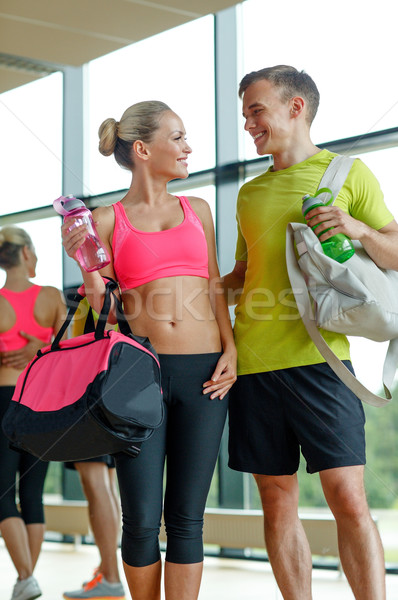 smiling couple with water bottles in gym Stock photo © dolgachov