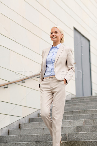 young smiling businesswoman walking down stairs Stock photo © dolgachov