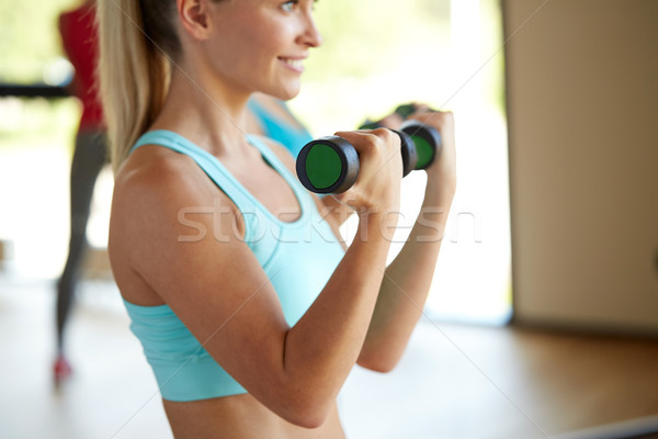 Stock photo: closeup of woman with dumbbells in gym