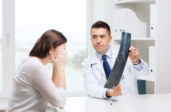smiling male doctor in white coat looking at x-ray Stock photo © dolgachov