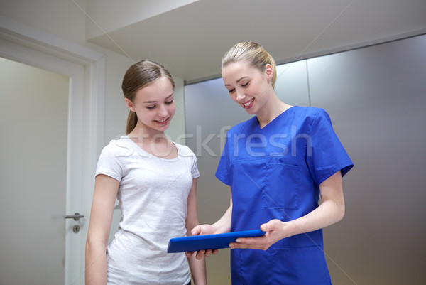 smiling nurse with tablet pc and girl at hospital Stock photo © dolgachov