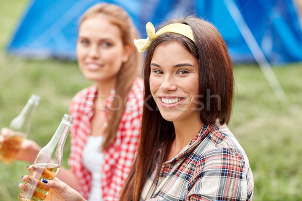 happy young women with tent and drinks at campsite Stock photo © dolgachov