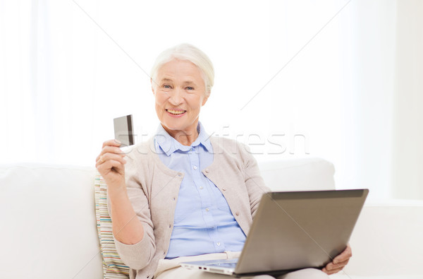 senior woman with laptop and credit card at home Stock photo © dolgachov