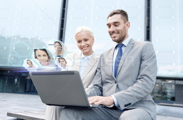 smiling businesspeople with laptop outdoors Stock photo © dolgachov