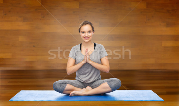 woman making yoga meditation in lotus pose on mat Stock photo © dolgachov