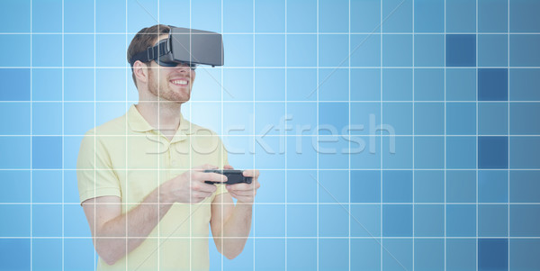Stock photo: happy man in virtual reality headset with gamepad