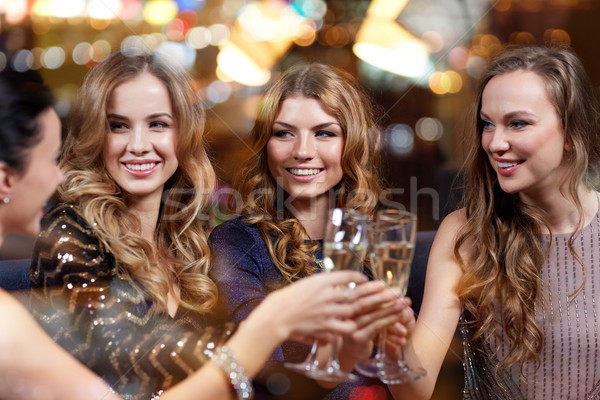 Stock photo: happy women with champagne glasses at night club