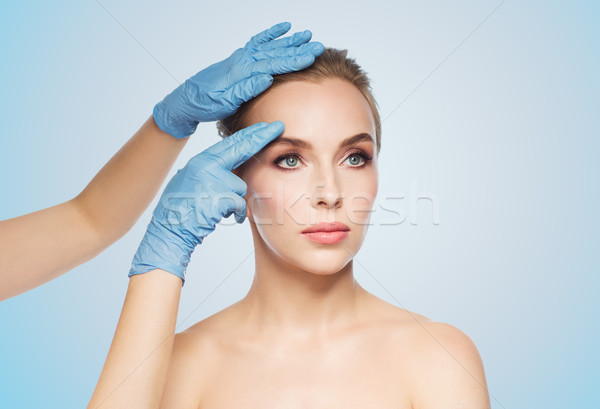 Stock photo: surgeon or beautician hands touching woman face