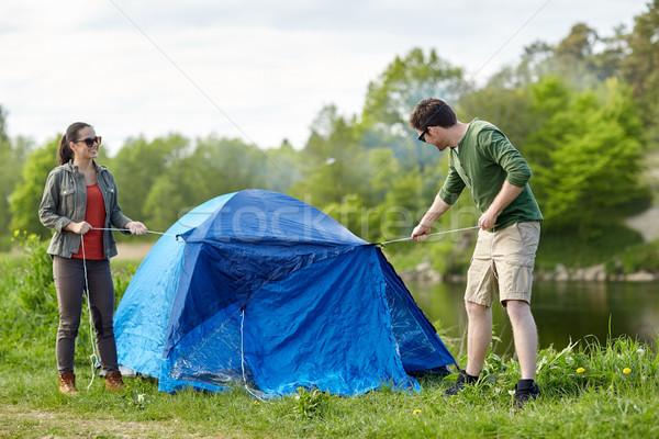 happy couple setting up tent outdoors Stock photo © dolgachov