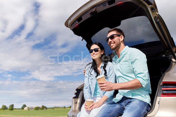 happy couple with coffee at hatchback car trunk Stock photo © dolgachov