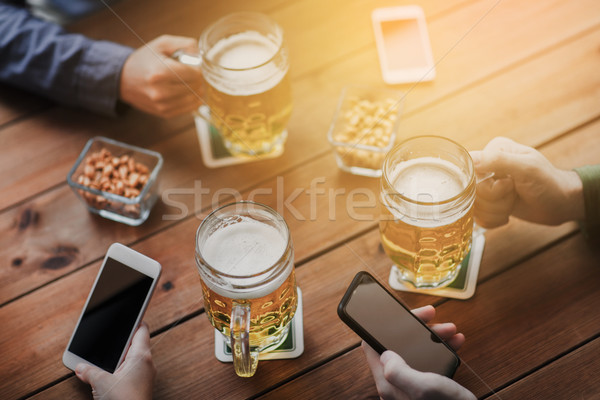 [[stock_photo]]: Mains · smartphones · bière · bar · personnes