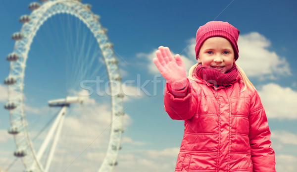 happy little girl waving hand over ferry wheel Stock photo © dolgachov