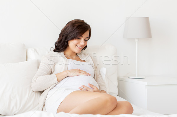 Imagine de stoc: Fericit · femeie · gravida · pat · acasă · sarcină · oameni