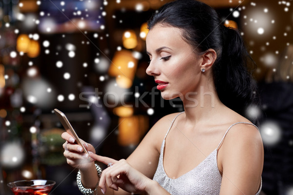 young woman with smartphone at night club or bar Stock photo © dolgachov