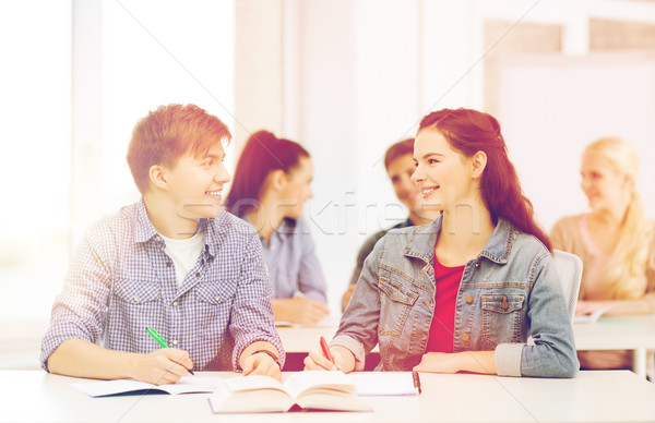 two teenagers with notebooks and book at school Stock photo © dolgachov