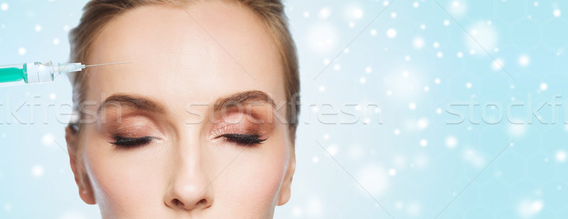 close up of woman face and syringe over snow Stock photo © dolgachov