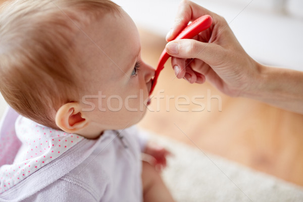 Stock photo: hand with spoon feeding little baby at home
