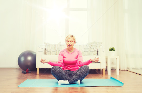 happy woman stretching leg on mat at home Stock photo © dolgachov