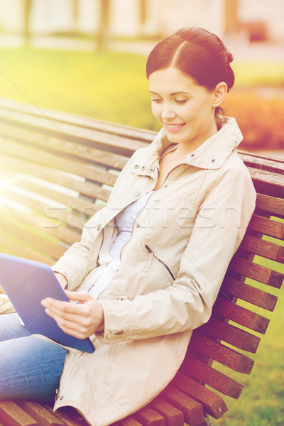 woman with tablet pc sitting on bench in park Stock photo © dolgachov
