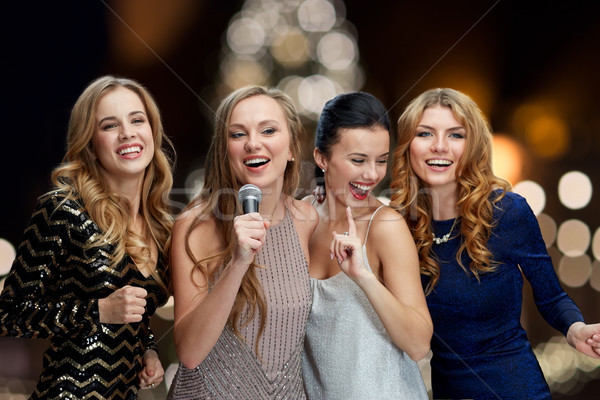 women with microphone singing karaoke at christmas Stock photo © dolgachov