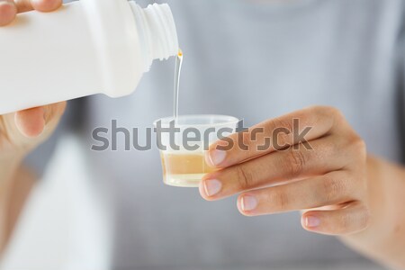 Femeie sirop sticlă medicină ceaşcă Imagine de stoc © dolgachov